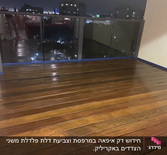 מרפסת עץ עם מעקה זכוכית בלילה